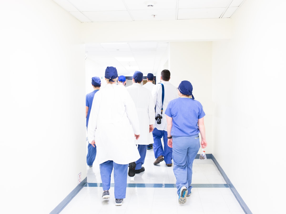 Equipa clínica a caminhar num corredor de hospital